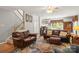 Comfortable living room showcases a staircase, plush leather furniture, and warm, inviting decor at 171 Highland Woods Ct, Denver, NC 28037