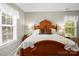 Cozy main bedroom with windows and a classic wood headboard flanked by bedside lamps at 171 Highland Woods Ct, Denver, NC 28037