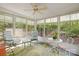 Bright sunroom featuring lots of windows, ceiling fan and a cozy seating area with views of the landscaped backyard at 171 Highland Woods Ct, Denver, NC 28037