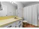 Well-lit bathroom with a single sink vanity and white shower curtain at 1748 4Th Street Ne Ct, Hickory, NC 28601