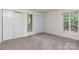 Carpeted bedroom with neutral tones, closet doors, and natural light offers a cozy retreat at 1748 4Th Street Ne Ct, Hickory, NC 28601