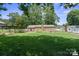 Backyard featuring well-maintained lawns and a brick house with mature trees creating a peaceful outdoor oasis at 1787 Eastover Dr, Mount Pleasant, NC 28124