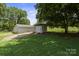 Backyard featuring well-maintained lawns, storage sheds, and mature trees, offering a perfect blend of functionality and nature at 1787 Eastover Dr, Mount Pleasant, NC 28124