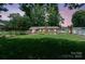 Backyard featuring well-maintained lawns and a brick house with mature trees creating a peaceful outdoor oasis at 1787 Eastover Dr, Mount Pleasant, NC 28124