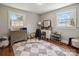 Bright bedroom with two windows, a wooden dresser, a desk and a checkerboard pattern rug at 1787 Eastover Dr, Mount Pleasant, NC 28124