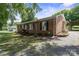 Charming brick home featuring black shutters, landscaped yard, and a gravel driveway, shaded by mature trees at 1787 Eastover Dr, Mount Pleasant, NC 28124