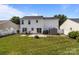 A well-maintained backyard with a white fence, green lawn, and small patio with a fire pit at 1901 Summit Ridge Ln, Kannapolis, NC 28083
