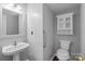 Cozy bathroom featuring a pedestal sink, grab bar, and storage cabinet above the toilet at 1901 Summit Ridge Ln, Kannapolis, NC 28083
