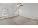 Bright bedroom with neutral carpet, white walls, two windows, and ceiling fan with overhead lighting at 1901 Summit Ridge Ln, Kannapolis, NC 28083