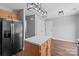 Open-concept kitchen with black refrigerator, center island, and hardwood floors at 1901 Summit Ridge Ln, Kannapolis, NC 28083
