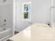Bathroom featuring a bathtub, shower, window and a single sink vanity with modern fixtures at 2005 Amos Oaks Ln, Charlotte, NC 28215