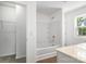 Bright white bathroom with bathtub, shower, and storage shelves, complimented by a large window at 2005 Amos Oaks Ln, Charlotte, NC 28215