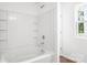 Clean, all-white bathroom with bathtub, shower, and a window providing natural light at 2005 Amos Oaks Ln, Charlotte, NC 28215