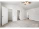 Spacious bedroom with vaulted ceilings features a ceiling fan, carpeted floors and multiple closets at 2005 Amos Oaks Ln, Charlotte, NC 28215