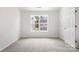 Bright, carpeted bedroom with large window and a neutral color scheme showcases simplicity and comfort at 2005 Amos Oaks Ln, Charlotte, NC 28215