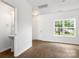 Open living room with wood floors and white walls and a convenient half bathroom at 2005 Amos Oaks Ln, Charlotte, NC 28215