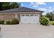 A bright white garage door with brick exterior, complimented by flower planters and a well kept concrete driveway at 203 Poplins Grove Church Rd, Albemarle, NC 28001
