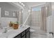 Modern bathroom featuring double sinks, marble tile, and a shower-tub combination at 205 Church St, Mcadenville, NC 28101