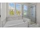 Elegant bathroom with a large soaking tub and a glass-enclosed shower featuring a modern design at 205 Church St, Mcadenville, NC 28101