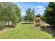 Spacious backyard featuring a playset, lush lawn, and mature trees, perfect for outdoor activities and relaxation at 2090 Durand Rd, Fort Mill, SC 29715