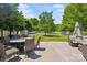 Landscaped backyard features a dining set, sitting area, mature trees, and lush lawn at 2090 Durand Rd, Fort Mill, SC 29715