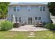 Back of house features a stone patio with dining and sitting areas and a landscaped yard at 2090 Durand Rd, Fort Mill, SC 29715