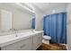 Bright bathroom features a modern double sink vanity, a large mirror, and blue shower curtain at 2090 Durand Rd, Fort Mill, SC 29715