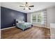 Bright bedroom features a modern ceiling fan, stylish accent wall, and a large window with bright natural light at 2090 Durand Rd, Fort Mill, SC 29715