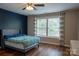 Cozy bedroom featuring a navy accent wall, hardwood floors, and bright windows at 2090 Durand Rd, Fort Mill, SC 29715