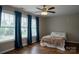 Bright bedroom featuring three large windows with a ceiling fan and neutral wall paint at 2090 Durand Rd, Fort Mill, SC 29715