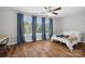 Bright bedroom features hardwood floors, a ceiling fan, large windows, and modern blue curtains at 2090 Durand Rd, Fort Mill, SC 29715