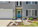 Inviting front entrance with a blue door, decorative wreath, potted plants, and stone landscaping at 2090 Durand Rd, Fort Mill, SC 29715