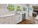 Bright kitchen features stainless steel appliances, white cabinets, stylish backsplash, and natural light from the windows at 2090 Durand Rd, Fort Mill, SC 29715