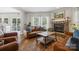 Cozy living room featuring a brick fireplace, hardwood floors, and comfortable leather furniture at 2090 Durand Rd, Fort Mill, SC 29715