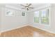 Empty bedroom with hardwood floors, ceiling fan, and multiple windows flooding the space with natural light at 2523 Irwin Stream Rd, Charlotte, NC 28208