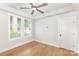 Empty bedroom features hardwood floors, a ceiling fan, bright windows, and a white door with black hardware at 2523 Irwin Stream Rd, Charlotte, NC 28208