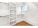 Walk-in closet with built-in shelves, natural light, and hardwood floors at 2523 Irwin Stream Rd, Charlotte, NC 28208