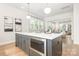 Spacious kitchen island featuring gray cabinets, microwave, quartz countertop and pendant lighting at 2523 Irwin Stream Rd, Charlotte, NC 28208