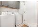 Convenient laundry room featuring a side-by-side washer and dryer with gray cabinets for extra storage at 2523 Irwin Stream Rd, Charlotte, NC 28208