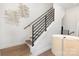 Modern staircase featuring hardwood floors, white risers, and a sleek metal railing at 2523 Irwin Stream Rd, Charlotte, NC 28208