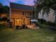 Spacious backyard with a stone patio, dining set, and charming pergola with lights for outdoor entertaining at 3006 S Legacy Park Blvd, Indian Land, SC 29707