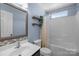 Well-lit bathroom featuring a bathtub, shower, decorative shelves, and tiled vanity at 3006 S Legacy Park Blvd, Indian Land, SC 29707