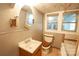 Modest bathroom featuring a wood vanity, toilet, and a partially visible bathtub, with beadboard ceiling detail at 3220 Harmony Hwy, Harmony, NC 28634
