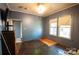 Cozy bedroom with refinished wood floors, dark grey walls, and natural light at 3220 Harmony Hwy, Harmony, NC 28634