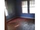 Sun-filled bedroom featuring original hardwood floors and a bank of windows at 3220 Harmony Hwy, Harmony, NC 28634