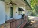 Inviting front porch features a ceiling fan, decorative 'HOME' sign, and patterned brick flooring at 3220 Harmony Hwy, Harmony, NC 28634