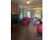 Inviting living room with brick fireplace and vintage charm, flooded with natural light and ample seating at 3220 Harmony Hwy, Harmony, NC 28634