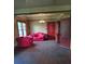 The living room provides ample space with a red sofa, vintage light fixture and storage at 3220 Harmony Hwy, Harmony, NC 28634