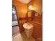Small bathroom with wood-paneled walls, a sink, mirror, and lighting at 370 Miracle Dr, Salisbury, NC 28146