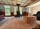 Cozy living area with a wood-burning stove, wood trim, and natural light from large windows at 370 Miracle Dr, Salisbury, NC 28146